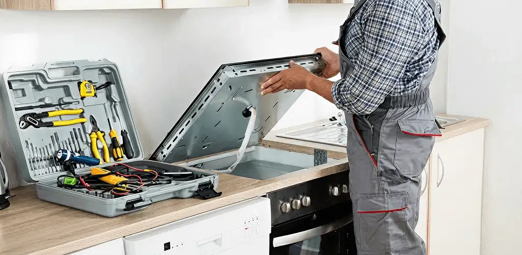 Handyman repairing a cooktop and checking wiring connections in Toledo, OH