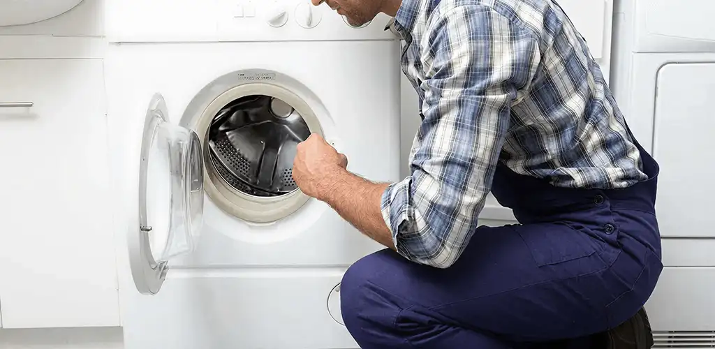 Handyman inspecting a dryer drum and internal parts for repair in Toledo, OH