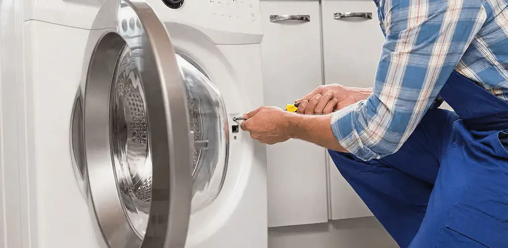Handyman repairing a clothes dryer and checking electrical connections in Toledo, OH
