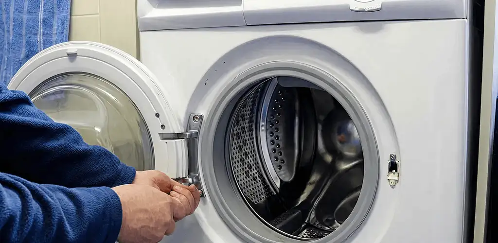 Washing machine repair handyman checking a front-load washer door and latch in Toledo, OH